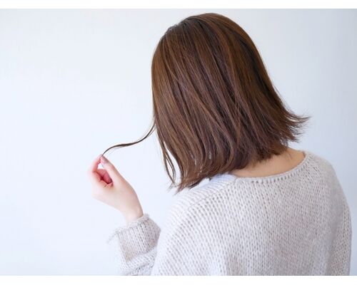 髪を気にする女性の写真