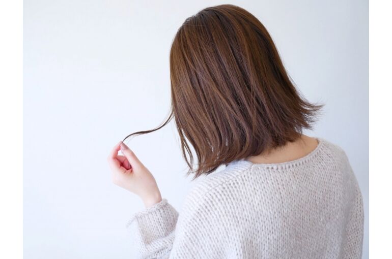 髪を気にする女性の写真