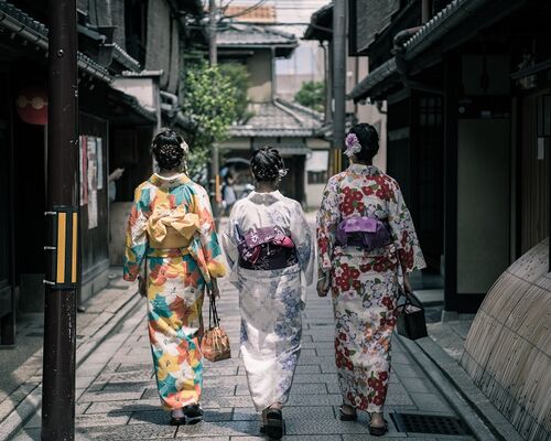 three-geisha-walking-between-buildings-1325837